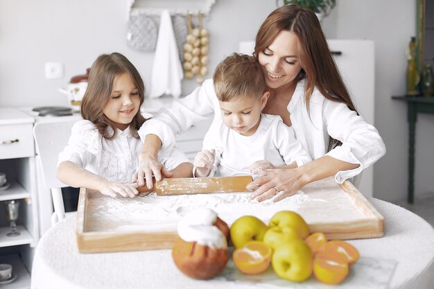 Familia sentada en una cocina y cocinar la masa para pastel