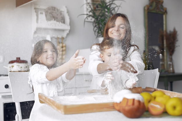 Familia sentada en una cocina y cocinar la masa para pastel