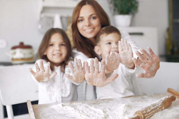 Familia sentada en una cocina y cocinar la masa para pastel