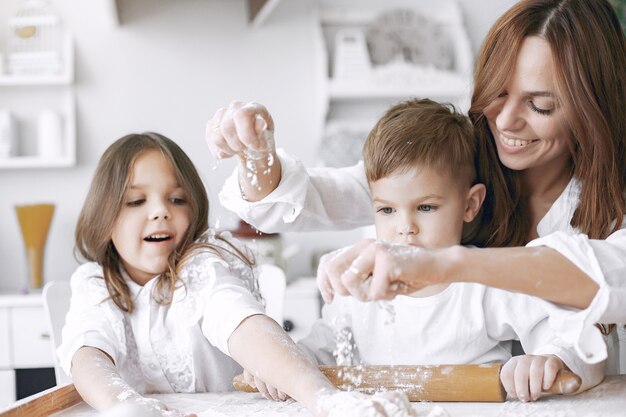 Familia sentada en una cocina y cocinar la masa para pastel