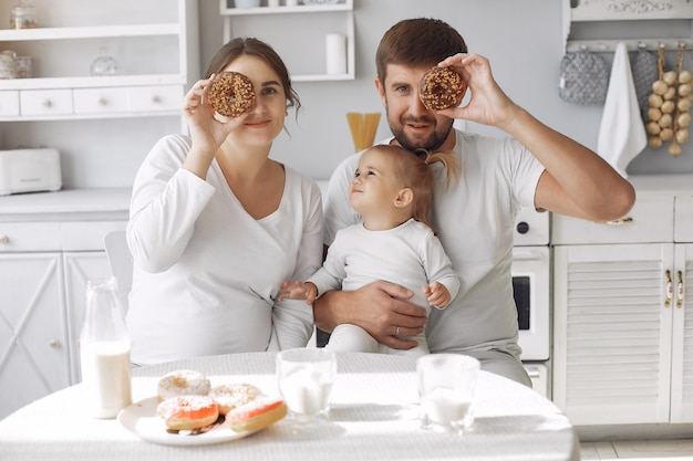 Familia sentada en la cocina y desayunando