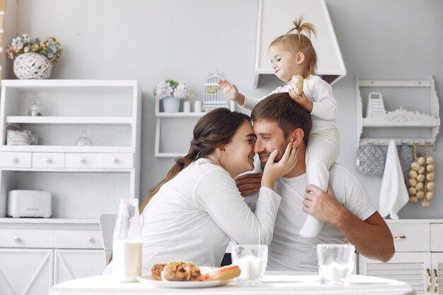 Familia sentada en la cocina y desayunando