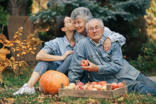Familia sentada en un jardín con manzanas y calabaza