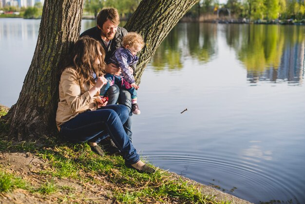 Familia sentada junto a un árbol