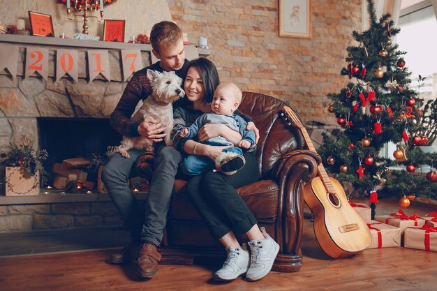 Familia sentada en un sofá con el perro en navidad