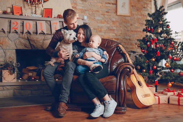 Familia sentada en un sofá con el perro en navidad