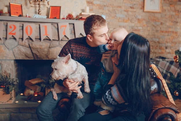 Familia sentada en un sofá con el perro en navidad