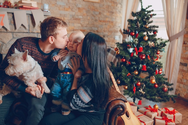 Familia sentada en un sofá con el perro en navidad