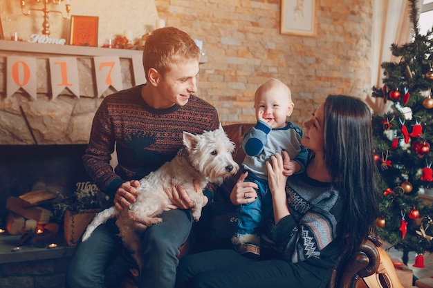 Familia sentada en un sofá con el perro en navidad