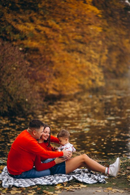 Familia, sentado, con, pequeño, hijo, por, el, lago