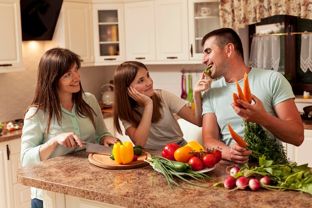 Familia sonriente en la cocina preparando comida