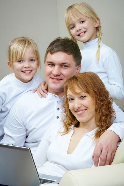 Familia sonriente sentado en el sofá de casa