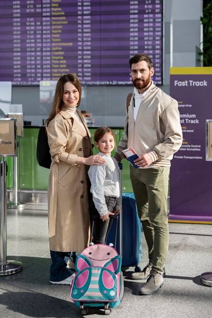 Familia sonriente de tiro completo con equipaje