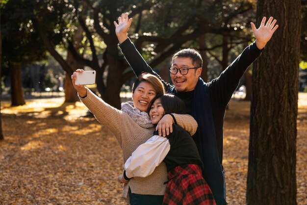 Familia sonriente de tiro medio en la naturaleza