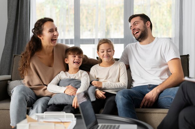 Familia sonriente de tiro medio sentado en el sofá