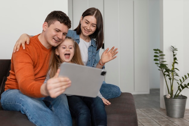 Familia sonriente de tiro medio con tableta