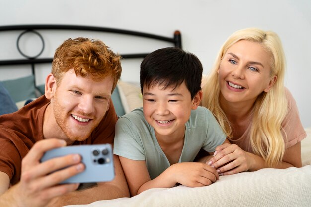 Familia sonriente de tiro medio tomando selfie