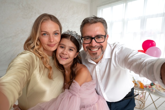 Familia sonriente tomando selfie vista frontal