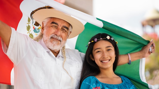 Foto gratuita familia sonriente con vista frontal de la bandera mexicana