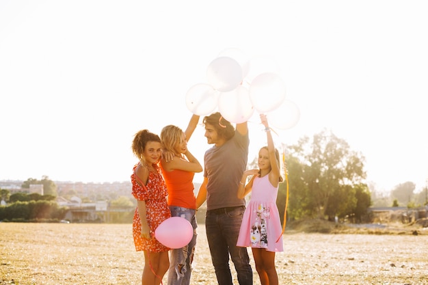 Familia sosteniendo un montón de globos sobre cabezas