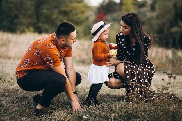 Foto gratuita familia con su pequeña hija en un bosque de otoño