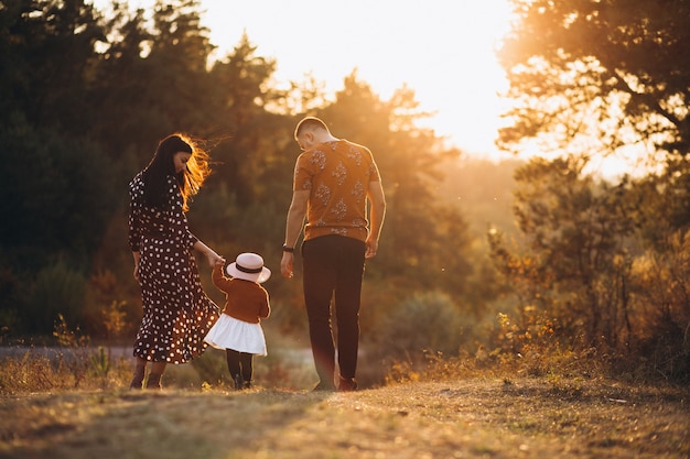 Familia con su pequeña hija en un campo de otoño