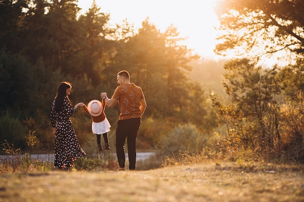 Familia con su pequeña hija en un campo de otoño