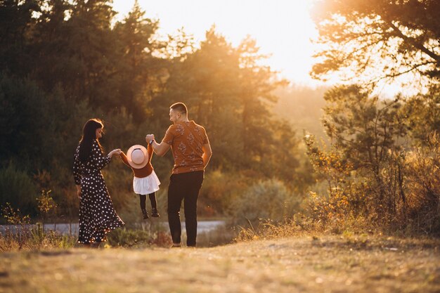 Familia con su pequeña hija en un campo de otoño