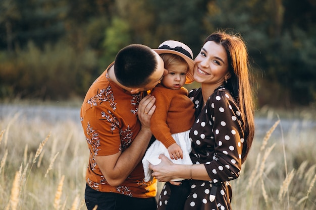 Foto gratuita familia con su pequeña hija en un campo de otoño