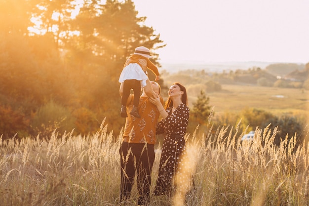 Familia con su pequeña hija en un campo de otoño