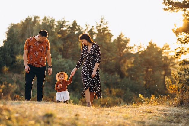 Familia con su pequeña hija en un campo de otoño