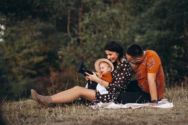 Familia con su pequeña hija haciendo un picnic en un campo