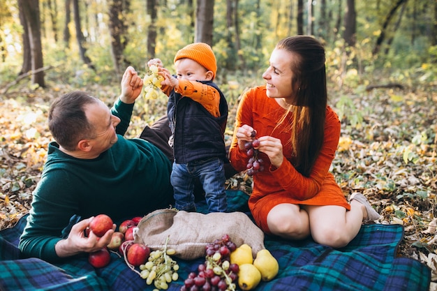 Familia con su pequeño hijo haciendo picnic en el parque