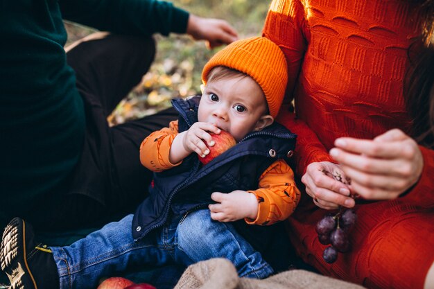 Familia con su pequeño hijo haciendo picnic en el parque