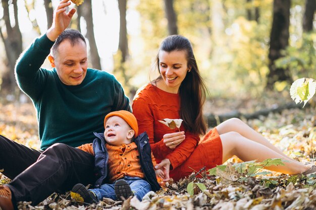 Familia con su pequeño hijo en un parque de otoño