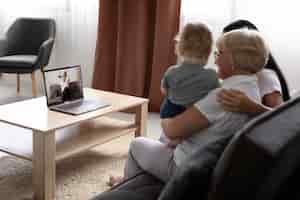 Foto gratuita familia teniendo una videollamada en casa