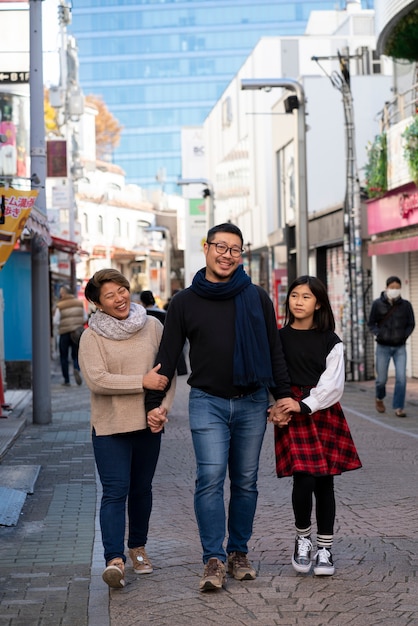 Familia de tiro completo caminando en la ciudad