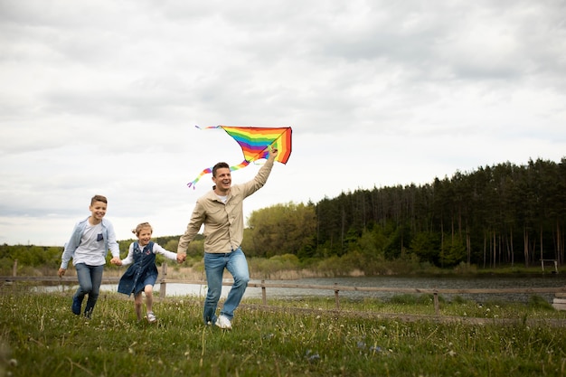 Familia de tiro completo con cometa arcoiris