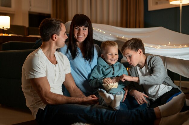 Familia de tiro completo comiendo palomitas de maíz