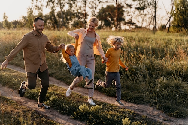 Familia de tiro completo corriendo en la pradera