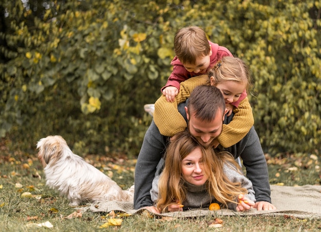 Foto gratuita familia de tiro completo divirtiéndose con perro