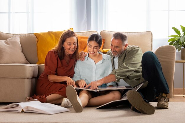 Familia de tiro completo mirando el álbum de fotos