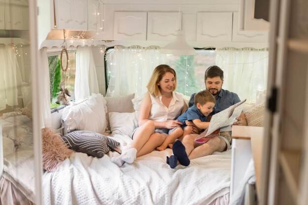 Familia de tiro largo mirando a través de un mapa en una caravana