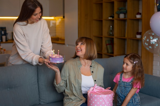 Foto gratuita familia de tiro medio celebrando con pastel