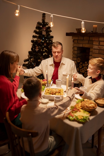 Foto gratuita familia de tiro medio cenando