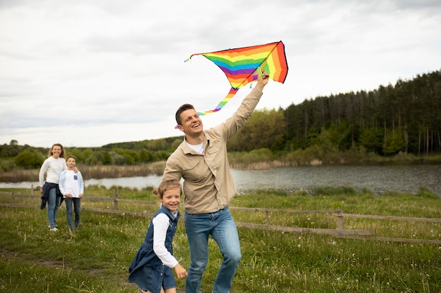 Familia de tiro medio con cometa arcoiris