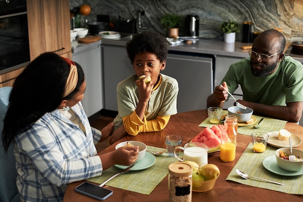 Familia de tiro medio comiendo en casa