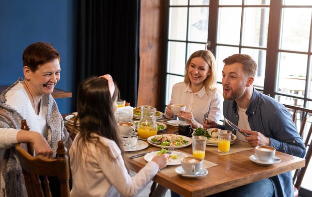 Familia de tiro medio comiendo juntos