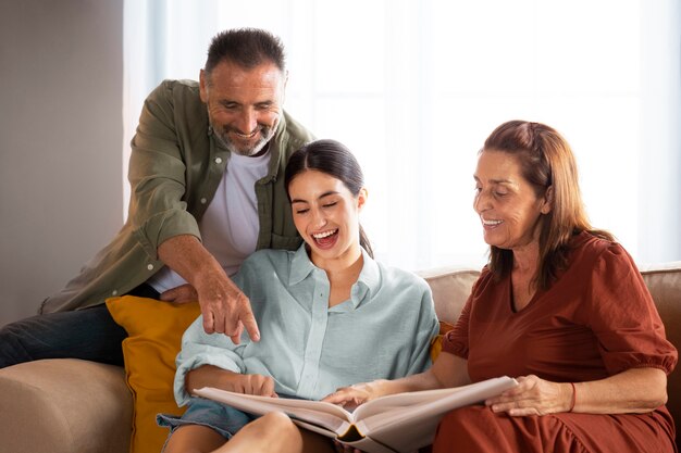 Familia de tiro medio mirando el álbum de fotos.