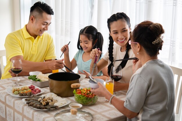 Familia de tiro medio sentado en la mesa